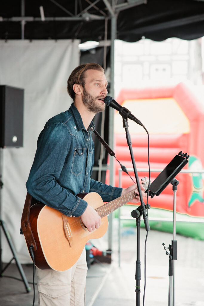 Der Musiker Niklas Vaupel spielt Gitarre und singt auf einer Bühne